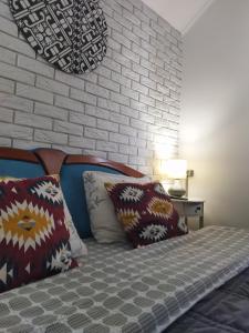 a bedroom with a bed with pillows and a brick wall at Захарова Оселя in Slavske