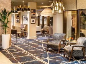 a lobby of a hotel with chairs and tables at Mercure Telford Centre Hotel in Telford