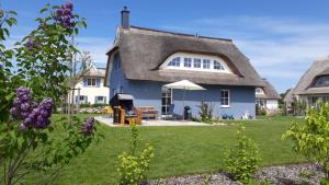 a blue house with a thatched roof at Ferienhaus Muscheltaucher in Kramerhof