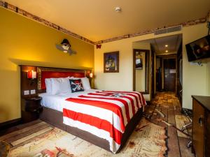 a bedroom with a bed with a red and white blanket at LEGOLAND(R) Windsor Resort in Windsor