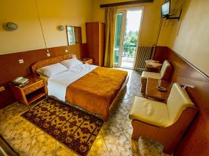 Habitación de hotel con cama y silla en Aegli Hotel en Atenas