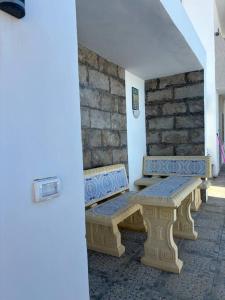 Villa luxe calme djerba في ميدون: كرسيان يجلسون بجوار جدار حجري
