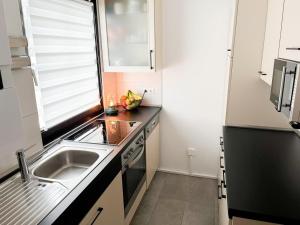 a small kitchen with a sink and a stove at Ferienhaus Nr 47, Kategorie Premium, Feriendorf Hochbergle, Allgäu in Bichel