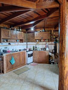 a large kitchen with wooden cabinets and a stove at Casa das nuvens in Itatiaia