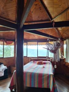 1 dormitorio con 1 cama en una habitación de madera en Casa das nuvens en Itatiaia