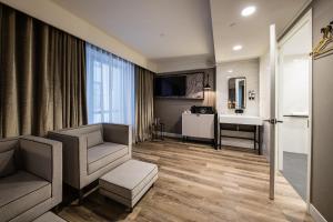 a living room with a couch and a desk and a sink at Pestana Park Avenue in New York