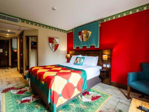 a bedroom with a bed and a red wall at LEGOLAND(R) Windsor Resort in Windsor