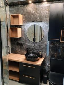 La salle de bains est pourvue d'un lavabo et d'un miroir. dans l'établissement Apartament EM, à Krosno