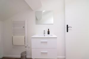 a white bathroom with a sink and a shower at Le Travi - Studio Hyper-Centre in Bergerac