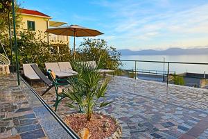 a patio with a table and chairs and an umbrella at Haus am Meer in Brist