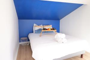 Habitación azul con cama y bandeja de fruta. en Le Travi - Studio Hyper-Centre, en Bergerac