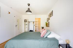 een slaapkamer met een bed met roze en blauwe kussens bij The Hadewijch - room nearby centre Bruges in Brugge