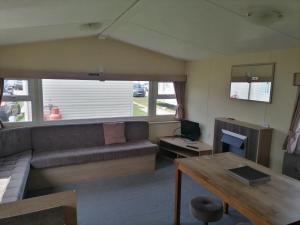 a living room with a couch and a table at Camber Sands Holiday Park in Camber