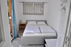 a small bedroom with a bed with white sheets at Boerenslag 22 in Sint Maartensvlotbrug +5 photos