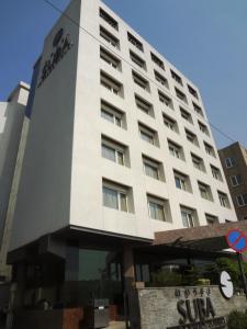 - un grand bâtiment blanc avec un panneau devant dans l'établissement Hotel Suba International, à Mumbai
