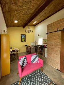 uma sala de estar com um sofá rosa e uma mesa em Prosa & Poesia! em Botucatu