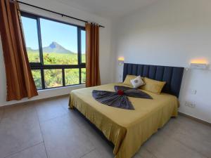 una camera da letto con un letto con una grande finestra di J'Vais Residence by SOV a Flic-en-Flac
