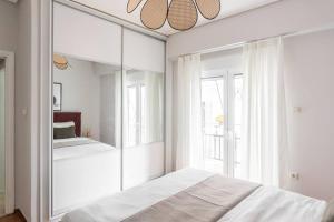 アテネにあるComfy 1BR Apartment in Ampelokipoi by UPSTREETの白いベッドルーム(鏡、ベッド付)