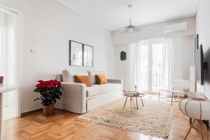 アテネにあるComfy 1BR Apartment in Ampelokipoi by UPSTREETの白いリビングルーム(白いソファ、テーブル付)
