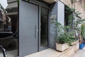 an open door of a building with potted plants at Comfy 1BR Apartment in Ampelokipoi by UPSTREET in Athens