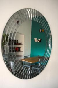 a circular mirror reflecting a table and chairs in a room at Ici c'est Cosy - Centre in Toulouse +6 photos