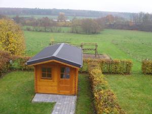 una piccola casa con tetto solare in un campo di Rustic renovated farmhouse with a private outdoor sauna in the garden a Somme-Leuze