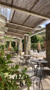 a patio with tables and chairs under a wooden ceiling at Hotel Villa Venus Resort & SPA in Atena Lucana