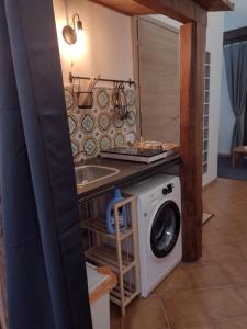 una cucina con lavatrice e lavandino di Casa di Teo-WI-FI-Smart TV a Velletri
