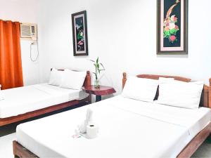 Camera bianca con 2 letti e un tavolo di Jurisu Resort a San Vicente