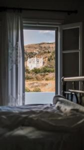 Agios RomanosにあるRomano garden house - land talesのベッドルーム1室(建物の景色を望む窓付)