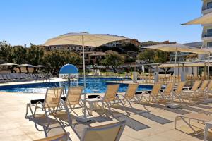a group of chairs and umbrellas next to a pool at THB Cala Lliteras in Cala Ratjada