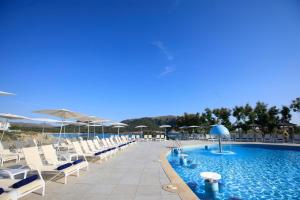 a swimming pool with lounge chairs and umbrellas at THB Cala Lliteras in Cala Ratjada