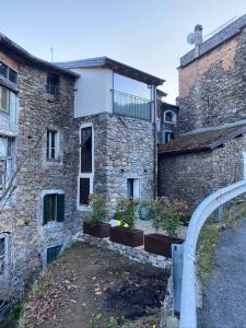 un edificio de piedra con plantas a su lado en Vicolo Rosso 2 en Dolceacqua