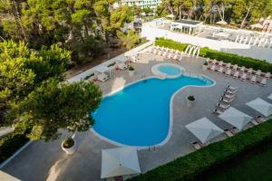 een uitzicht over een zwembad met tafels en stoelen bij THB Naeco Ibiza - Adults Only in San Antonio Bay