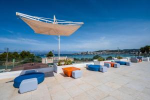 - un coin salon avec des chaises et un parasol dans l'établissement THB Naeco Ibiza - Adults Only, à Bahía de Sant Antoni