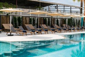 a swimming pool with lounge chairs and umbrellas at THB Bamboo Alcudia in Port d'Alcudia