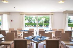 a dining room with tables and chairs and a large window at THB Dos Playas - Adults Only in Cala Ratjada