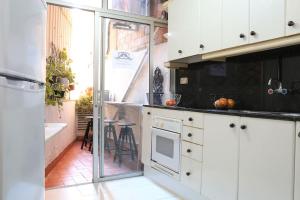 una cucina con armadi bianchi, lavandino e vasca di One bedroom Apartment in Eixample ! a Barcellona