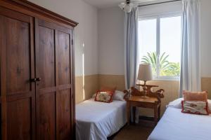a bedroom with two beds and a window at Finca San Diego with Pool & Wifi in La Matanza de Acentejo
