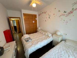 um quarto com duas camas e flores na parede em global 69 em Salobreña