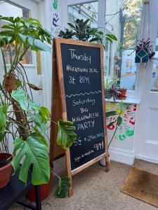 ein Schild an der Tafel vor einer Tür mit Pflanzen in der Unterkunft Prime Backpackers Angel in London