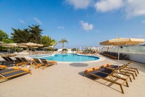聖安東尼奧灣的住宿－泰銖海洋海灘酒店，一个带躺椅和遮阳伞的游泳池