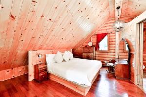 a bedroom with a bed in a wooden cabin at Cordelia with SPA Lake Nominingue 1min in Nominingue