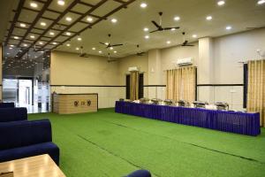 una sala de conferencias con suelo de moqueta verde y sillas en Hotel Crown Royal, en Kota