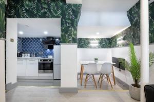 a kitchen with white cabinets and green wallpaper at 5WJB - Spacious 1 Bed Flat in London in London