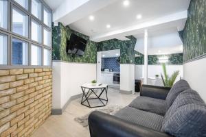 een woonkamer met een bank en een bakstenen muur bij 5WJB - Spacious 1 Bed Flat in London in Londen