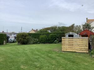 a yard with a wooden box in the grass at Haelarcher Helicopter Glamping in Helston