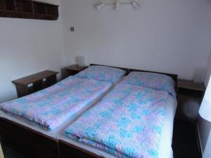 a bedroom with two beds with colorful sheets at Chata SLUKA in Poniklá +11 photos