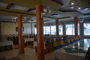 a banquet hall with tables and chairs and a clock at PC Green Hotel, Mahandri, Kaghan in Mingora