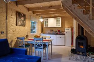 a kitchen and dining room with a table and a stove at Domki na Kaszubach u Madzi in Grabówko